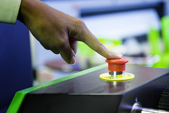 Cluse up emergency stop button push by finger for stopping machine